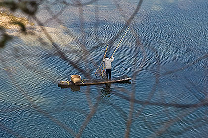 Fisherman on bamboo raft